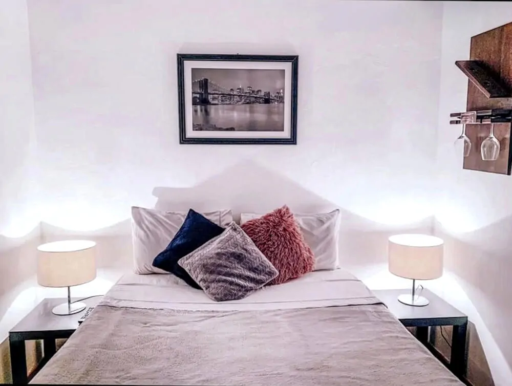 Quarto da Pousada Casa Recanto da Serra, com cama de casal e paredes brancas.