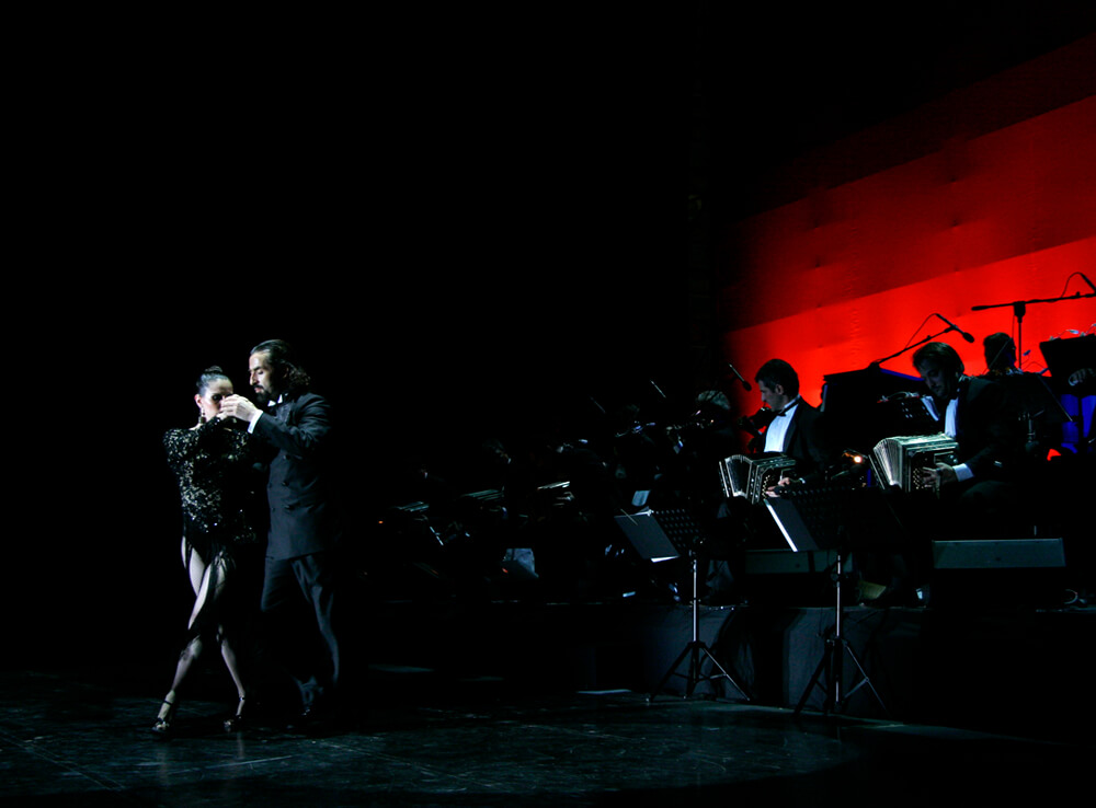 Dançarinos de tango se apresentando com banda, na cidade de Buenos Aires.