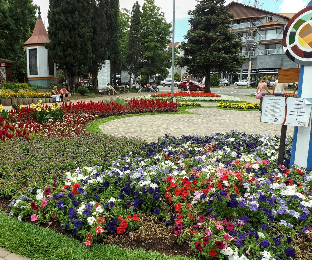 A Praça das Flores e seus canteiros vistos durante o dia.