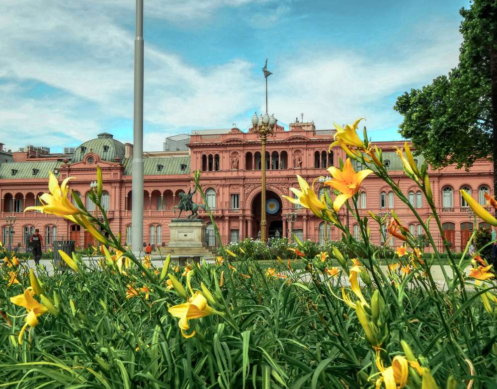 A Casa Rosada e flores da Plaza de Mayo vistas durante o dia.