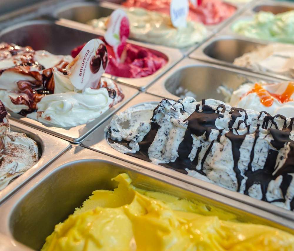 Sorvetes de diferentes sabores em um freezer expositor.