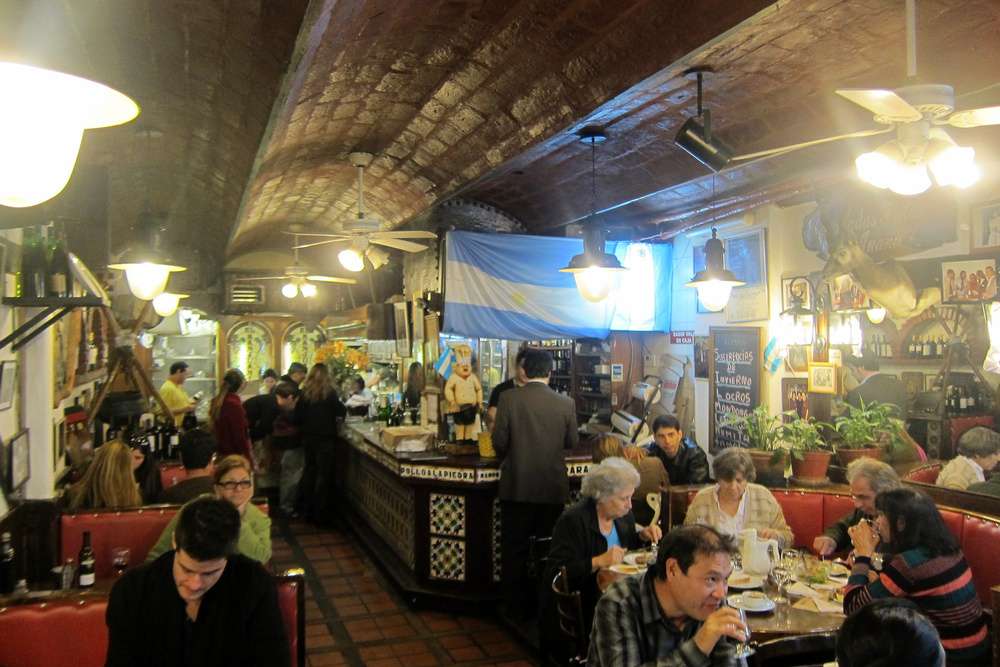 O interior do restaurante El Sanjuanino em uma noite movimentada.