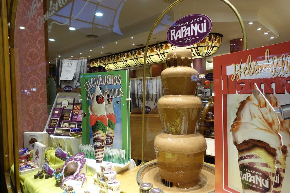 A vitrine da sorveteria Rapanui, com caixas de doces, sorvetes de papelão e uma fonte de chocolate.