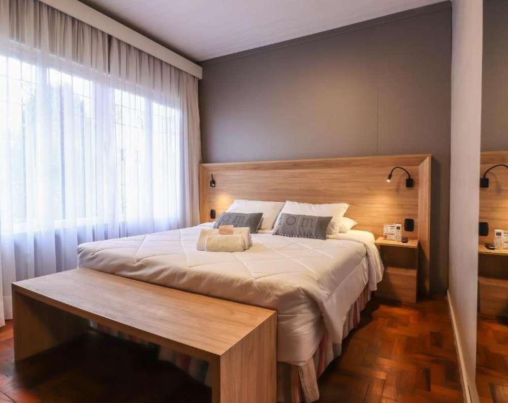 Quarto da Pousada Solar Viena em Gramado, com cama de casal, decoração moderna e aconchegante.