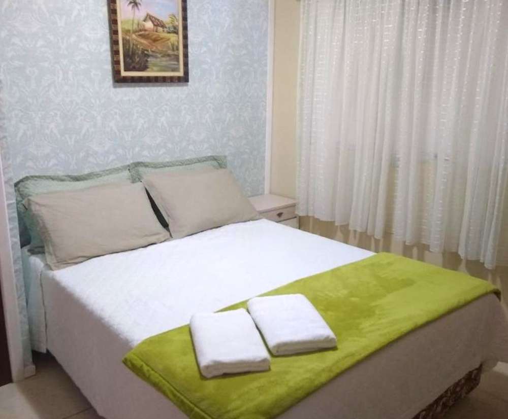 Quarto do Hostel Dina & Suítes, com cama de casal e visual acolhedor.