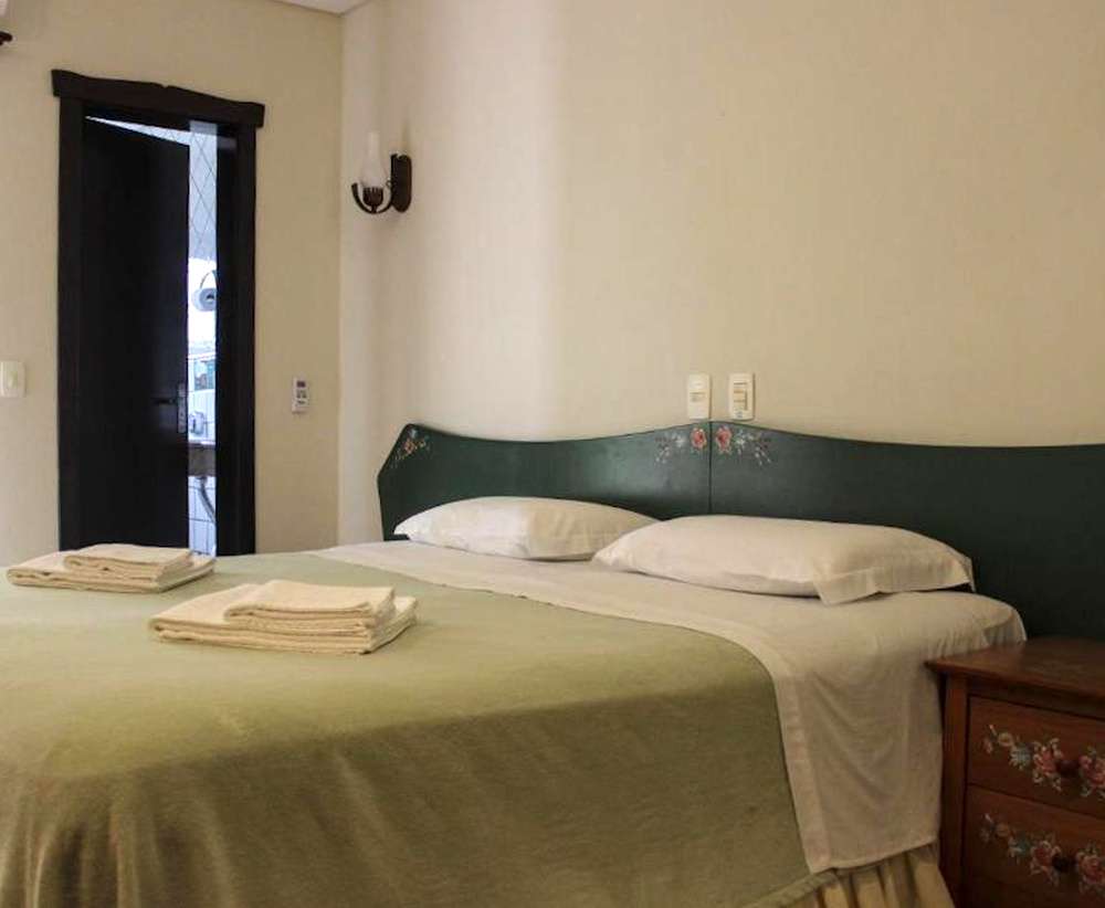 Quarto da Pousada Blauberg, com cama de casal e ambientação simples e clássica.