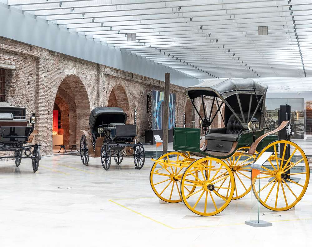 Carruagens antigas expostas no Museo Casa Rosada, em Buenos Aires, destacando veículos históricos em um ambiente de arquitetura colonial preservada.