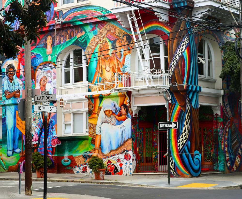 Mural colorido no Women's Building em San Francisco, destacando diversas mulheres em cenas vibrantes e culturais.