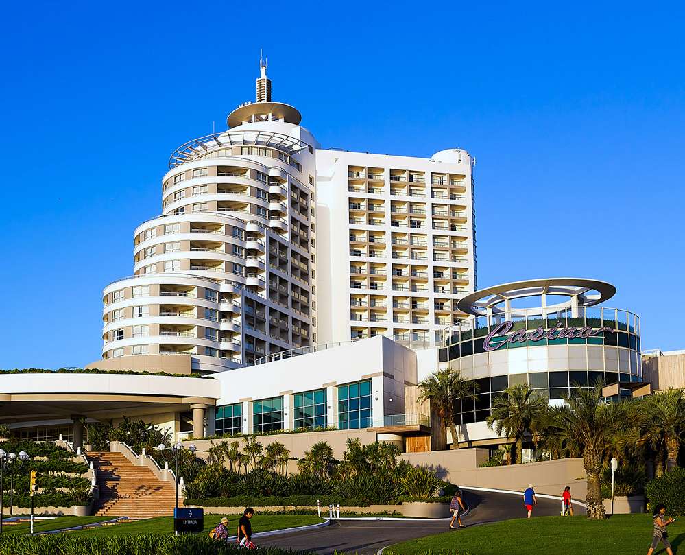 Fachada do Enjoy Punta del Este, com arquitetura moderna e entrada do cassino visível em um dia ensolarado.