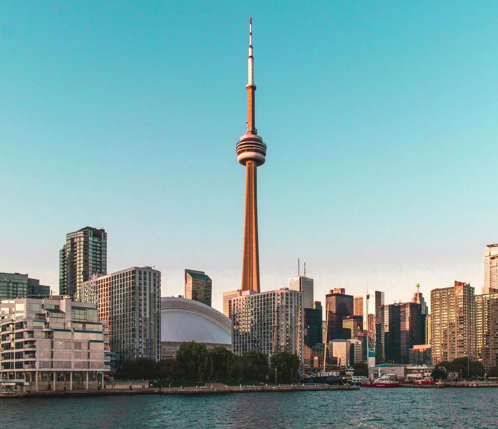 Um entardecer em Toronto com a Torre CN Tower se destacando entre os prédios.