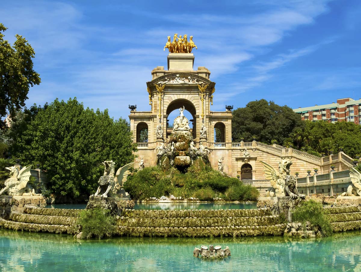 Fonte monumental cercada por água verde e esculturas em parque urbano em Barcelona