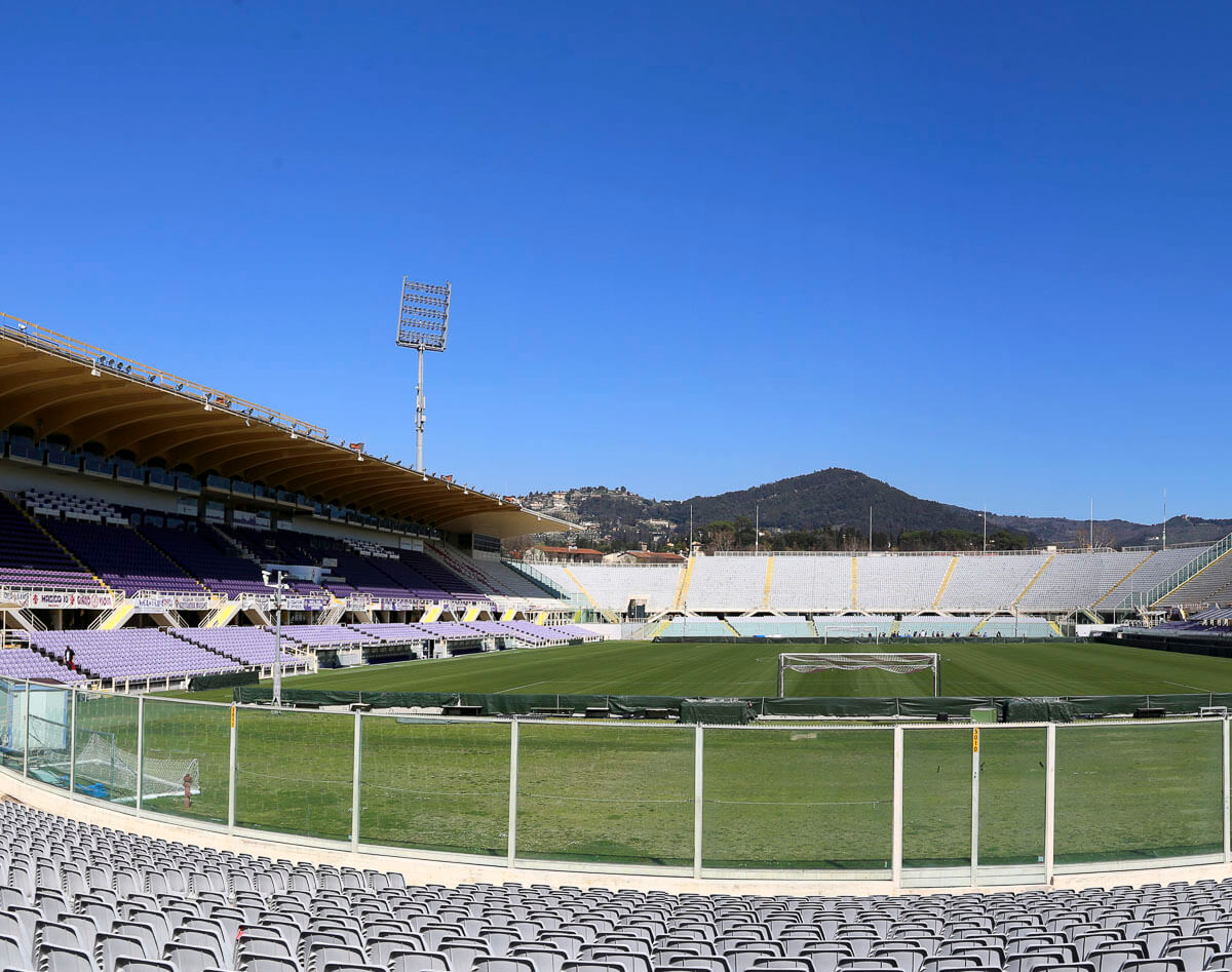 Estádio Artemio Franchi em Florença, com arquibancadas vazias e céu azul claro ao fundo.