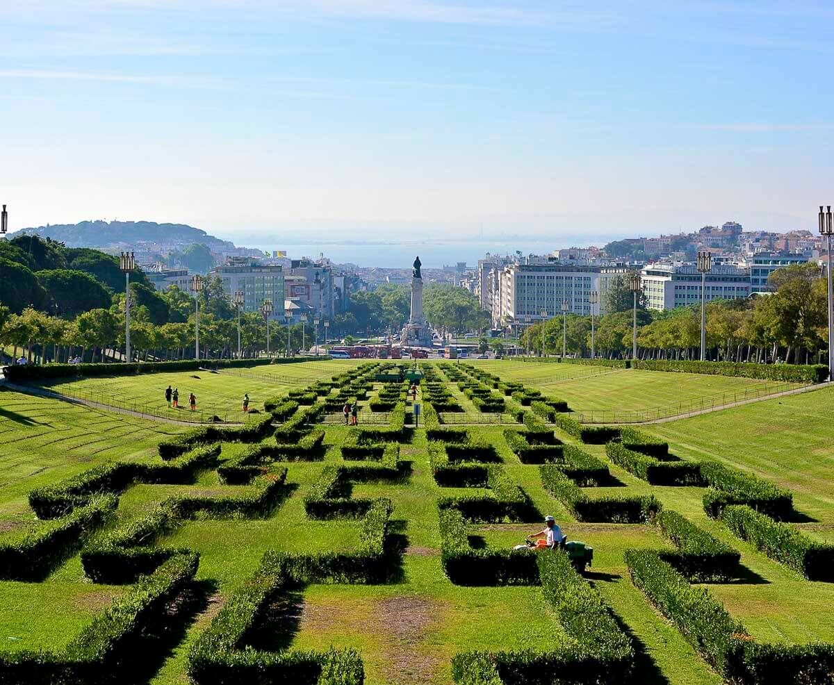 Parque Eduardo VII com uma vista para a estátua do Marquês de Pombal e a cidade de Lisboa ao fundo.