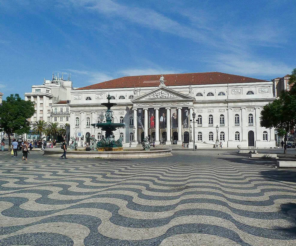 Praça do Rossio em Lisboa, com seu famoso calçadão ondulado e o Teatro Nacional D. Maria II ao fundo.