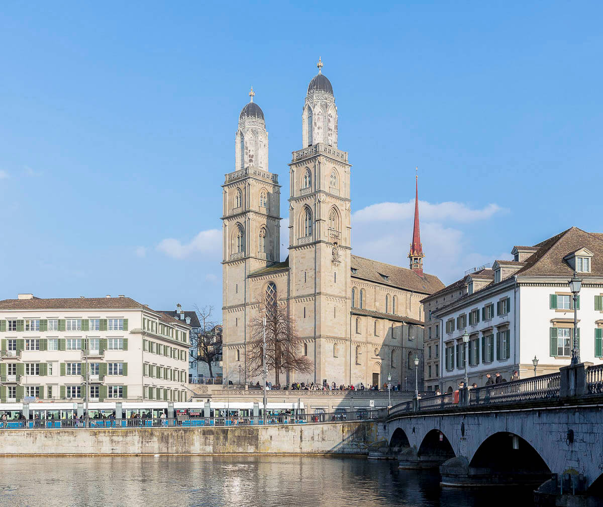 Igreja Grossmünster em Zurique, com duas torres gêmeas às margens do rio Limmat.