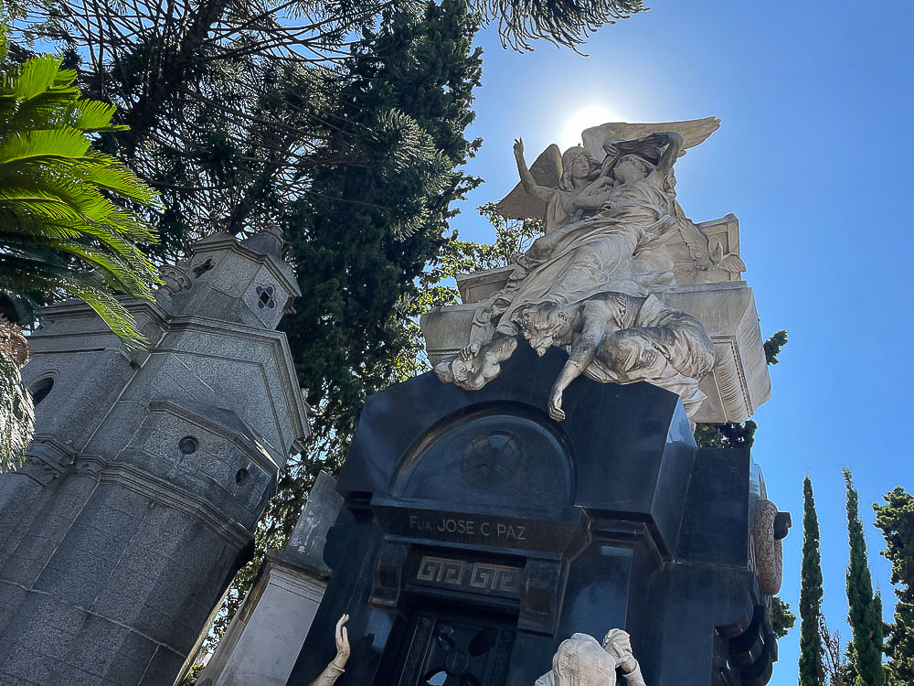 Mausoléu ornamentado no Cemitério da Recoleta, com uma escultura de anjos sobre o túmulo em Buenos Aires.