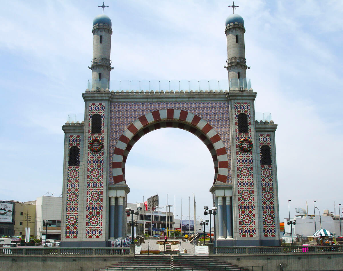 Monumento de estilo arquitetônico mourisco da Espanha com duas torres e um arco decorado, em um bairro de Lima.