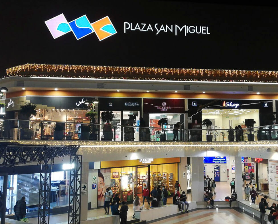O Shopping Plaza San Miguel iluminado à noite em Lima.