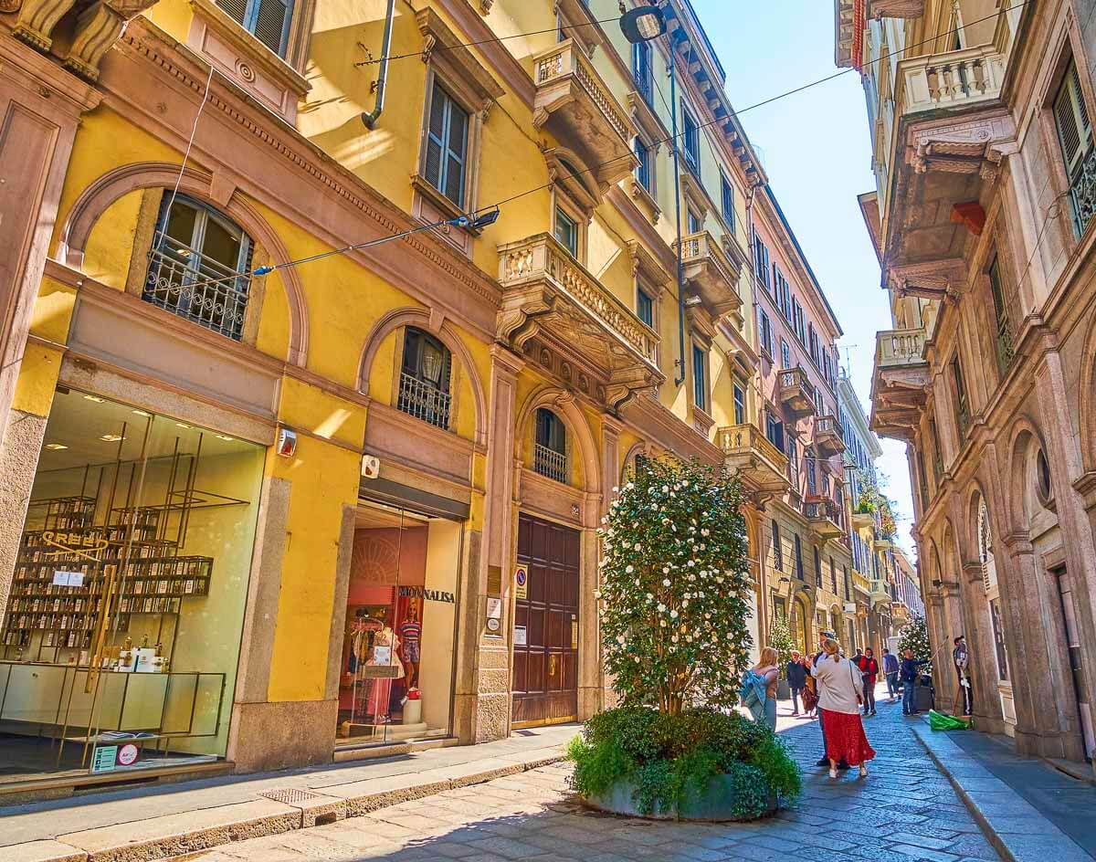 Rua luxuosa no Quadrilátero da Moda, com lojas sofisticadas e fachadas elegantes.
