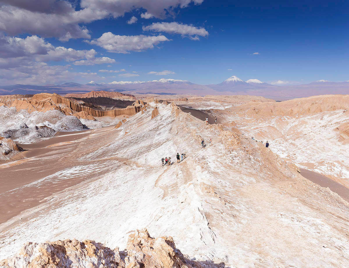 Trilhas no Valle de la Luna, no Deserto do Atacama, com montanhas e sal cobrindo o solo árido.