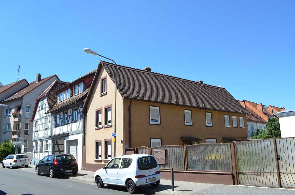 Casas residenciais no bairro Niederrad, em Frankfurt, com fachadas tradicionais e modernas alinhadas em uma rua tranquila.
