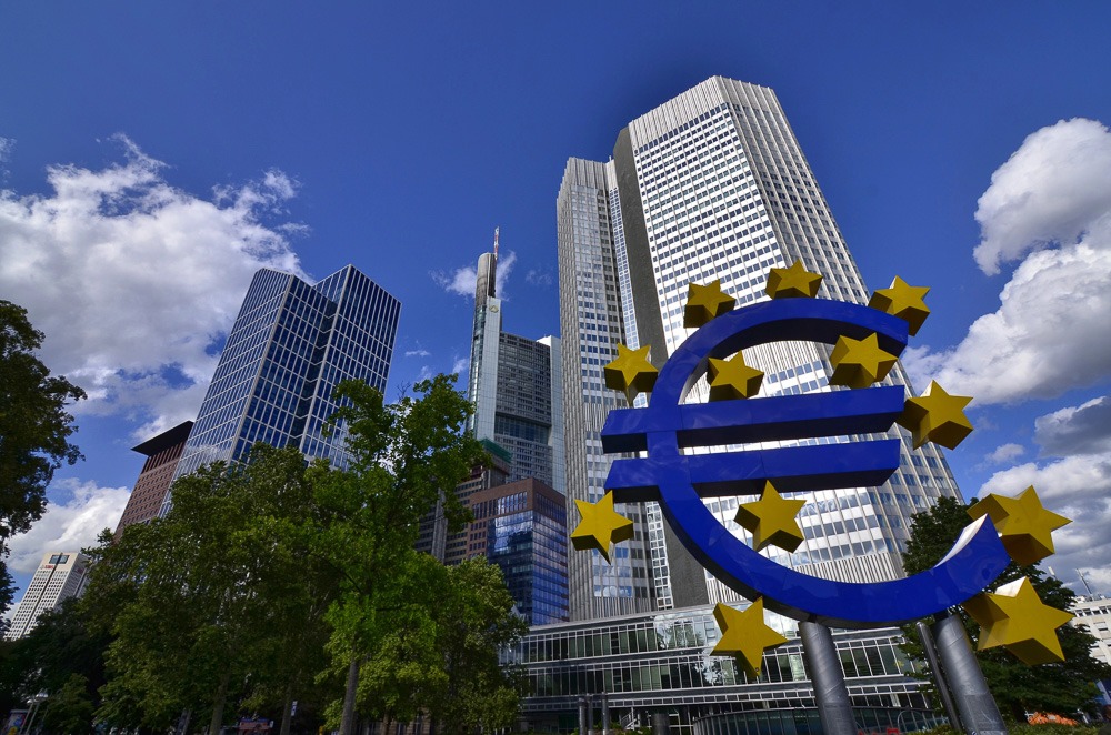 Escultura do símbolo do Euro com estrelas douradas em frente ao Banco Central Europeu, cercada por arranha-céus no distrito Ostend, Frankfurt.
