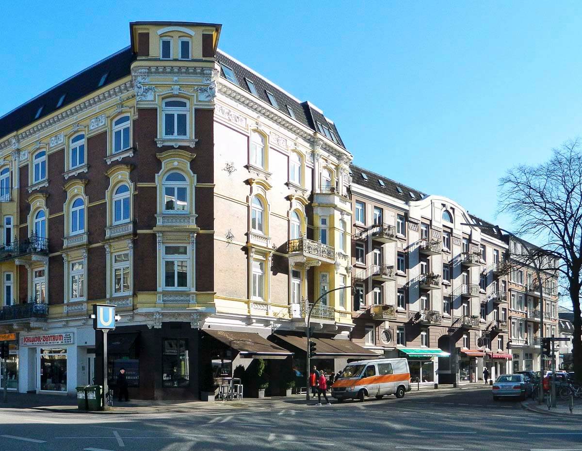 Prédio histórico no bairro de Eppendorf, em Hamburgo, com arquitetura ornamentada e uma estação de metrô próxima.