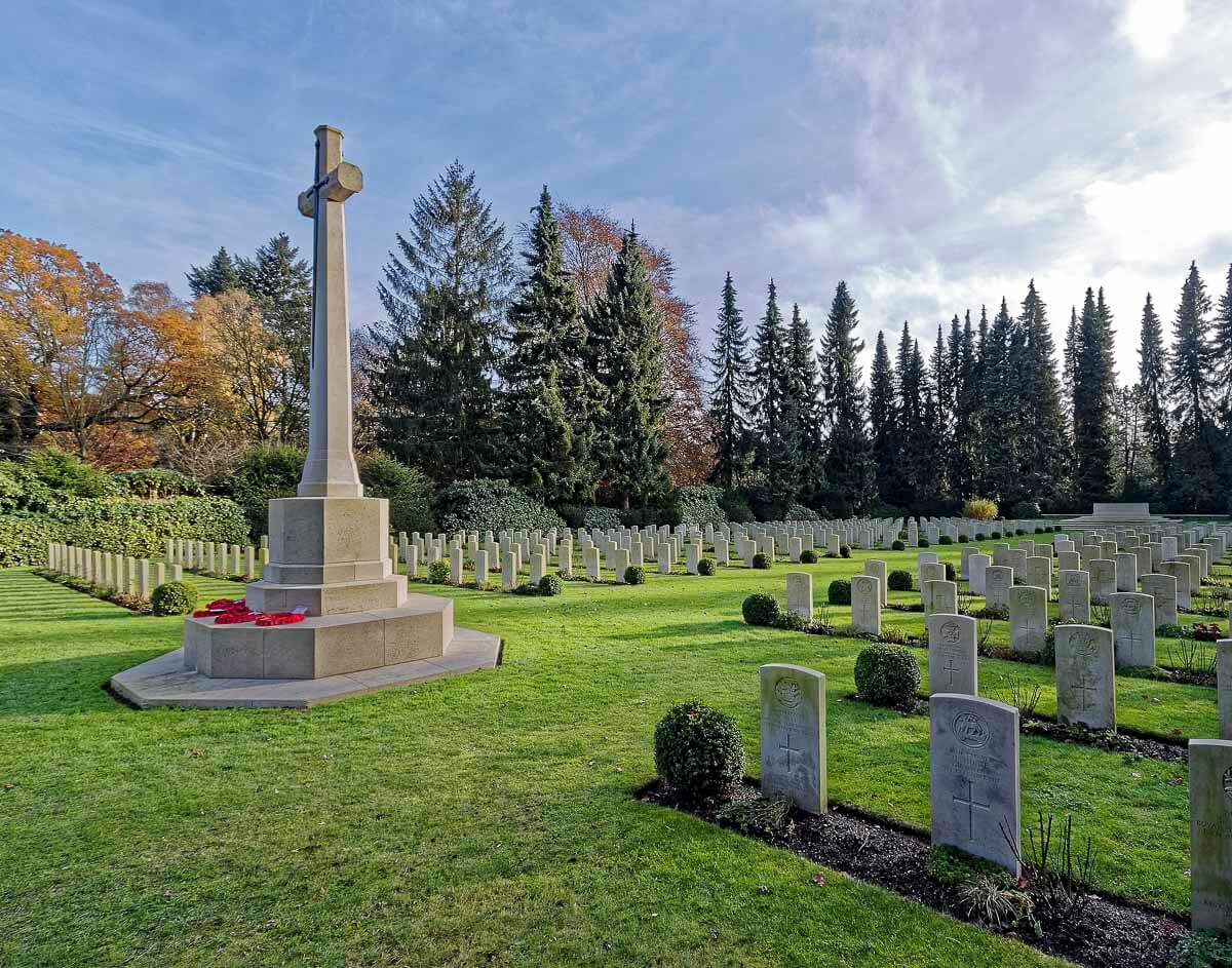 O Cemitério de Ohlsdorf com cruzes de pedra e um grande monumento em forma de cruz.