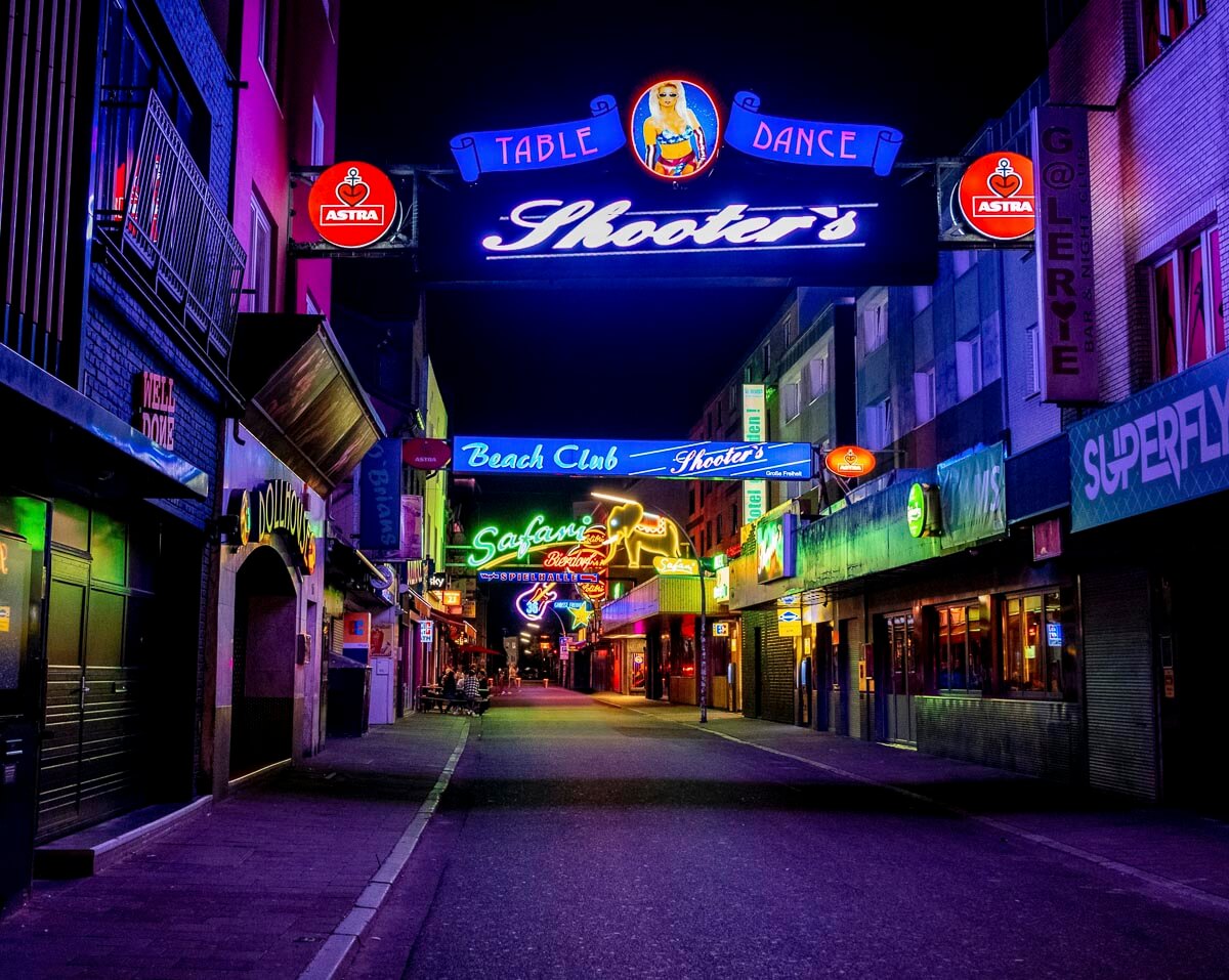 Letreiros neon brilhantes de bares e clubes em St. Pauli durante a noite.