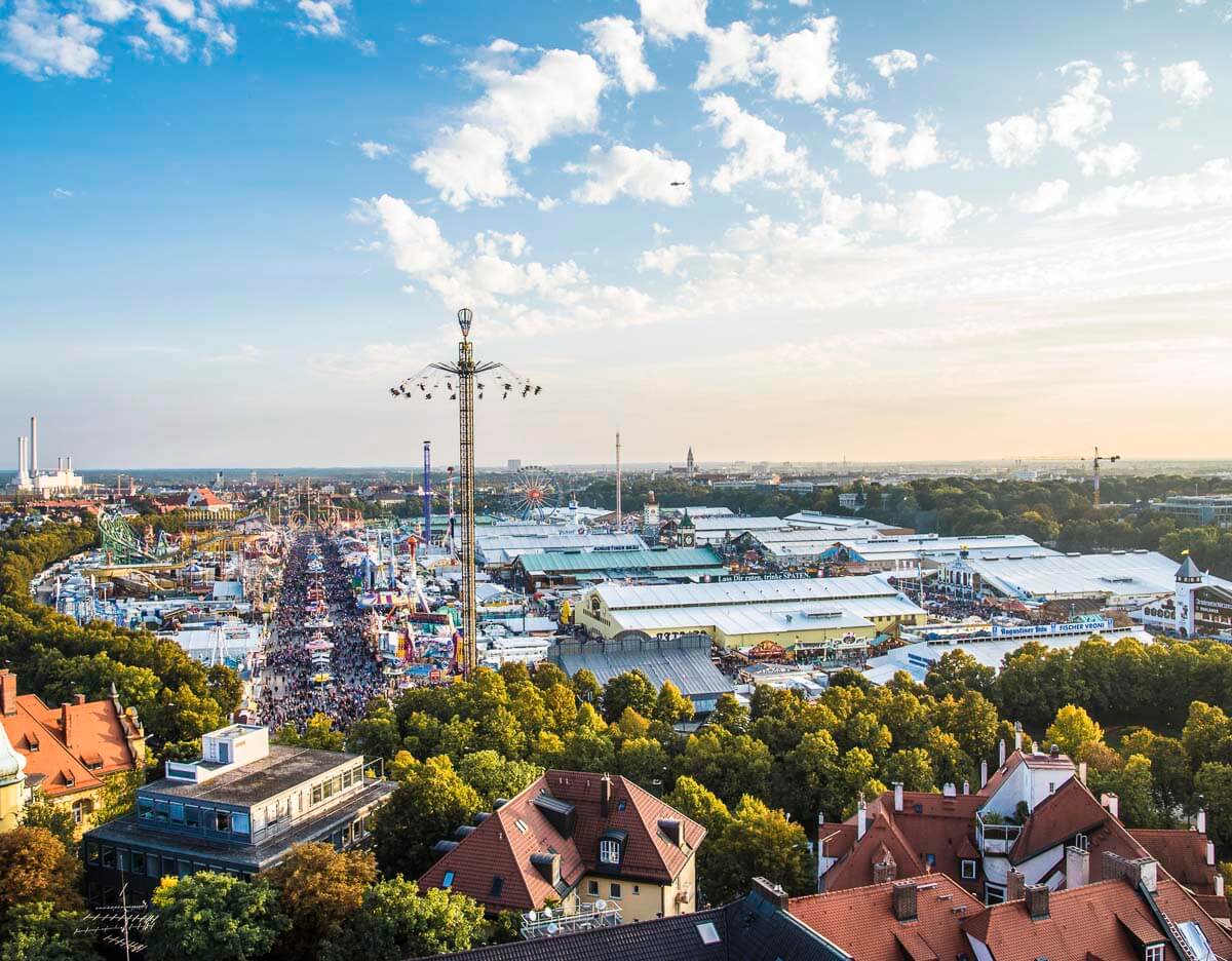 Vista panorâmica da Oktoberfest de Munique no bairro de Ludwigsvorstadt-Isarvorstadt, com tendas enormes, atrações e multidões apreciando o festival em Munique.