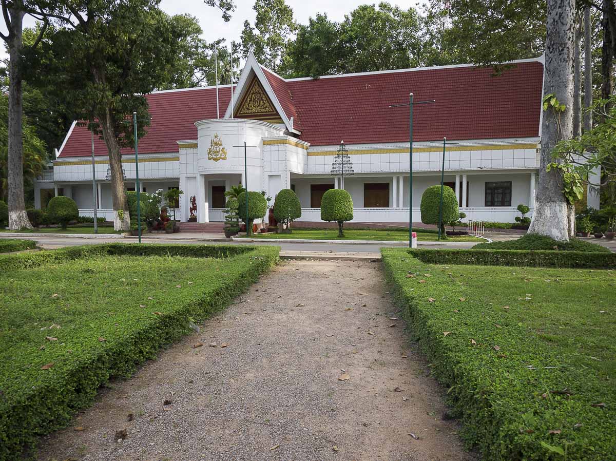 A Residência Real, com fachada branca e telhado vermelho cercado por jardins verdes, localizado na área histórica de Siem Reap.