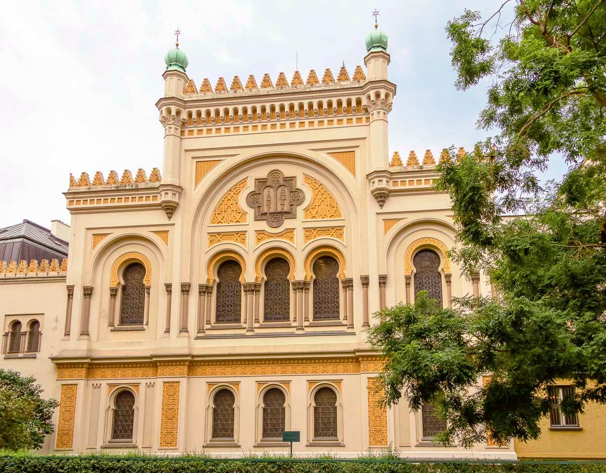 Fachada da Sinagoga Espanhola em Praga, com detalhes dourados e janelas em arco.