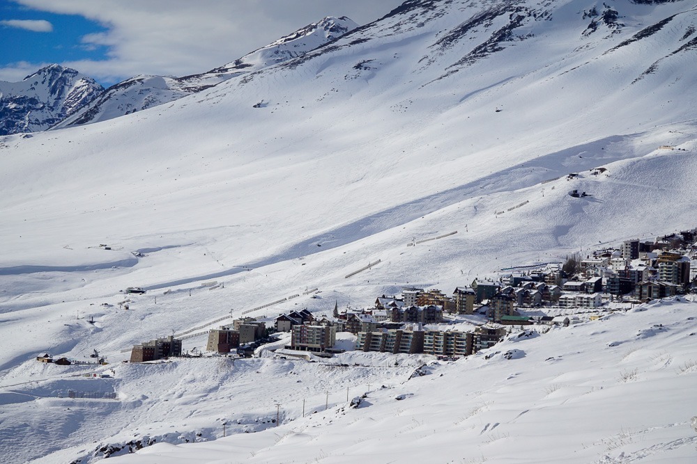 Estação de esqui nas montanhas nevadas de Farellones, com edifícios espalhados ao longo da encosta.