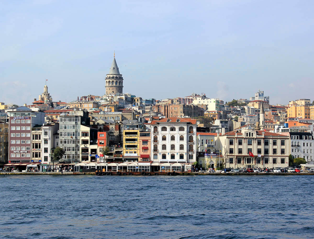 Vista panorâmica do bairro de Karaköy, em Istambul, com a Torre de Gálata ao fundo e prédios de diferentes estilos à beira do Bósforo.