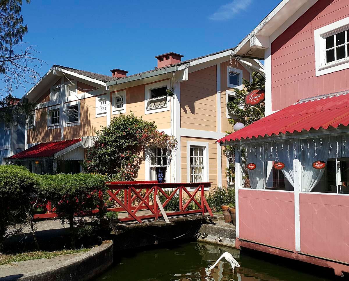 Casas em estilo europeu no centro de Penedo, com ponte vermelha e um pequeno canal.