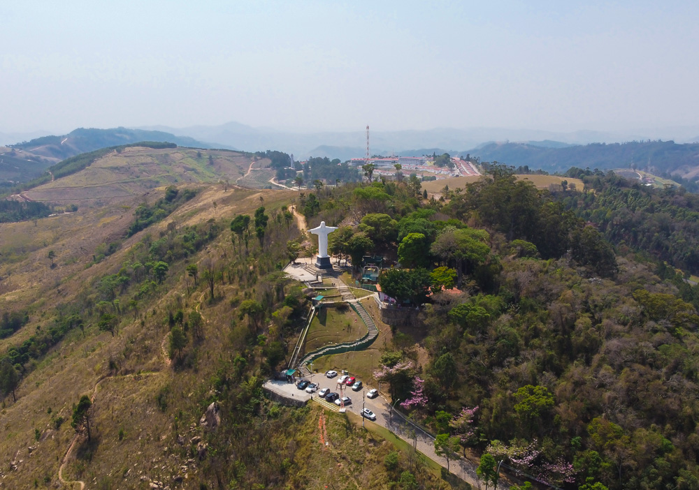 Mirante com o Cristo Redentor de Serra Negra visto de cima, rodeado por vegetação e morros, ideal para quem quer explorar onde ficar em Serra Negra com vista panorâmica.