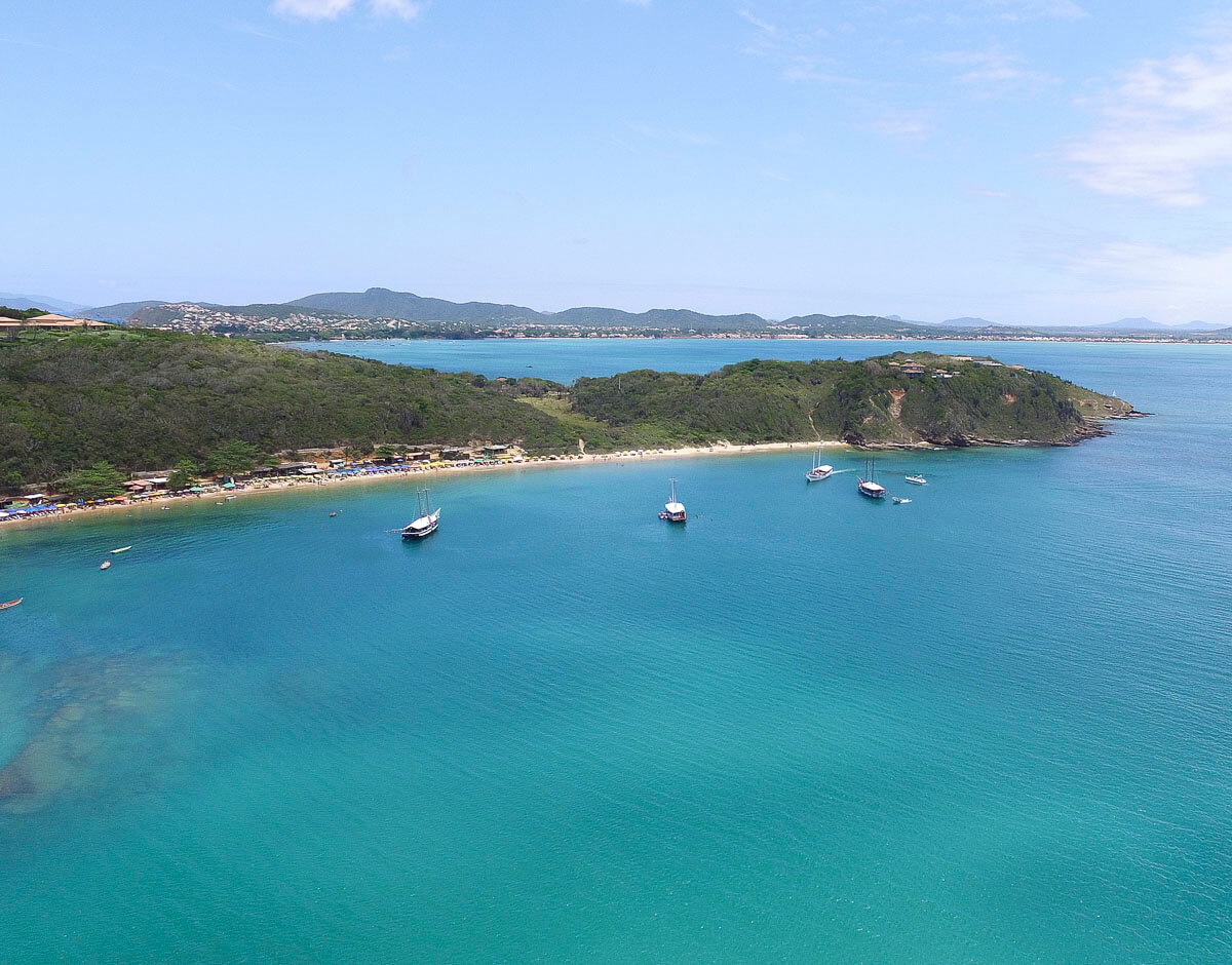 Praia da Tartaruga em Búzios com mar azul e barcos ancorados em águas calmas.