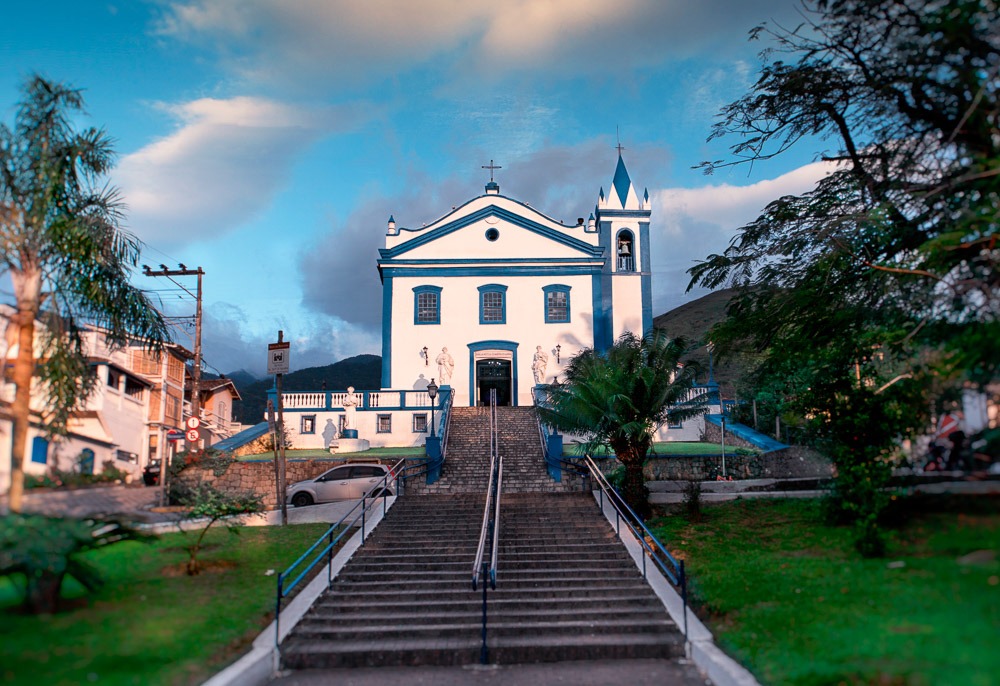 Fachada da Igreja Matriz Nossa Senhora d’Ajuda no centro de Ilhabela, com escadaria frontal.