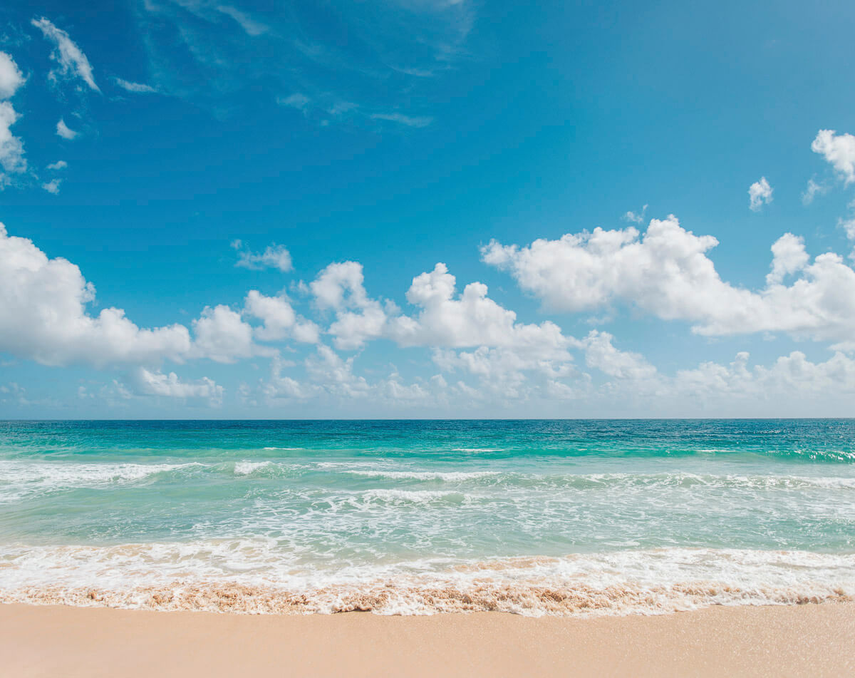 Praia de Macao em Punta Cana com areia clara, mar turquesa e céu azul com nuvens fofas.