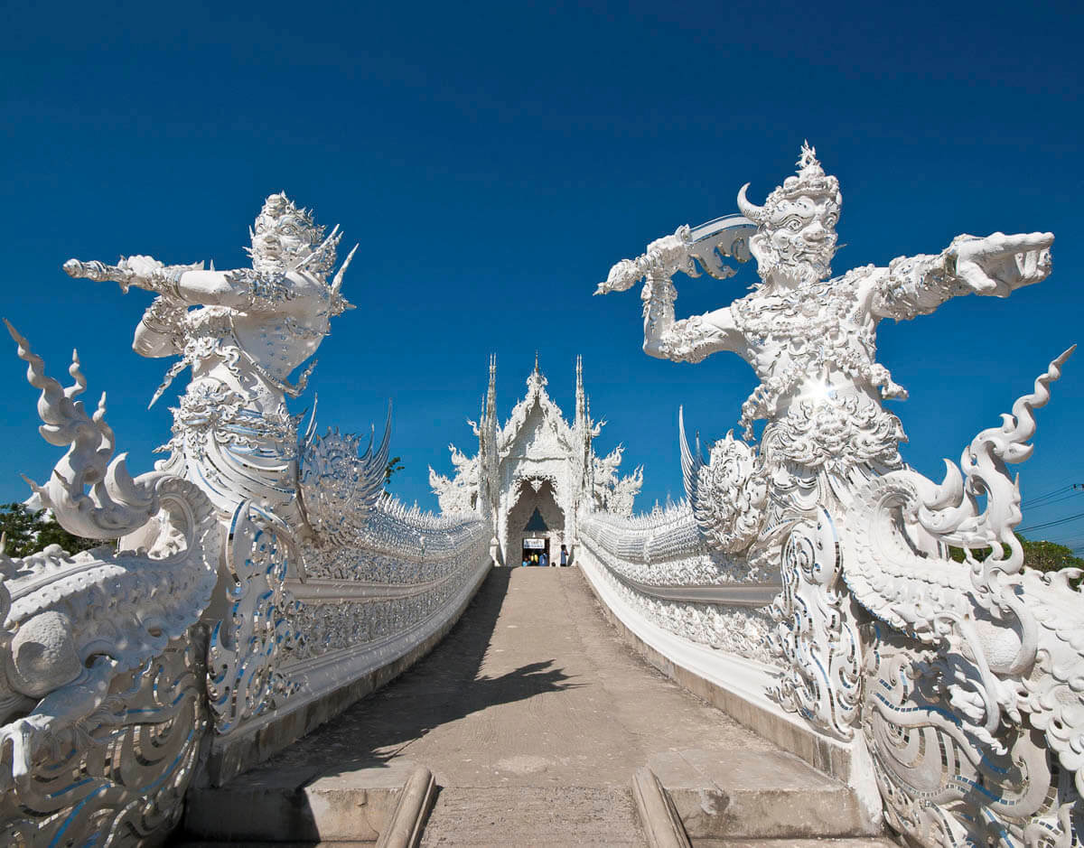 Escadaria do Templo Branco com duas esculturas guerreiras em branco em destaque.