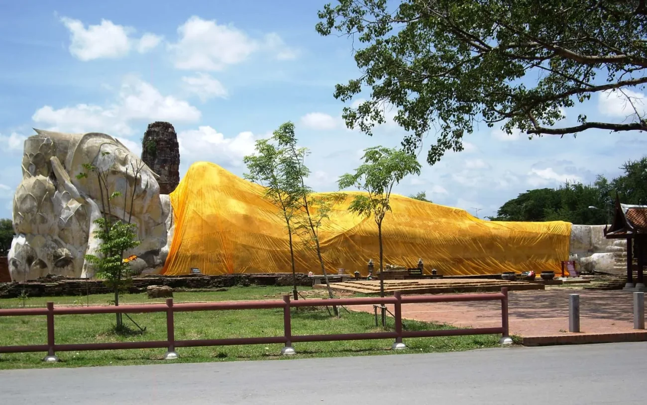 Estátua gigante de Buda reclinado coberta com tecido dourado no templo Wat Lokayasutharam.