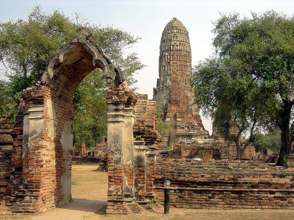 Ruínas do Wat Phra Ram em Ayutthaya, com portão antigo em destaque e chedi central ao fundo.