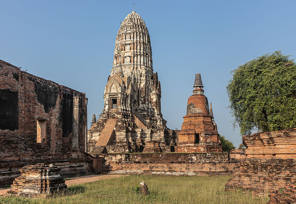Vista frontal do templo Wat Ratchaburana com sua torre principal e construções em ruínas ao redor.