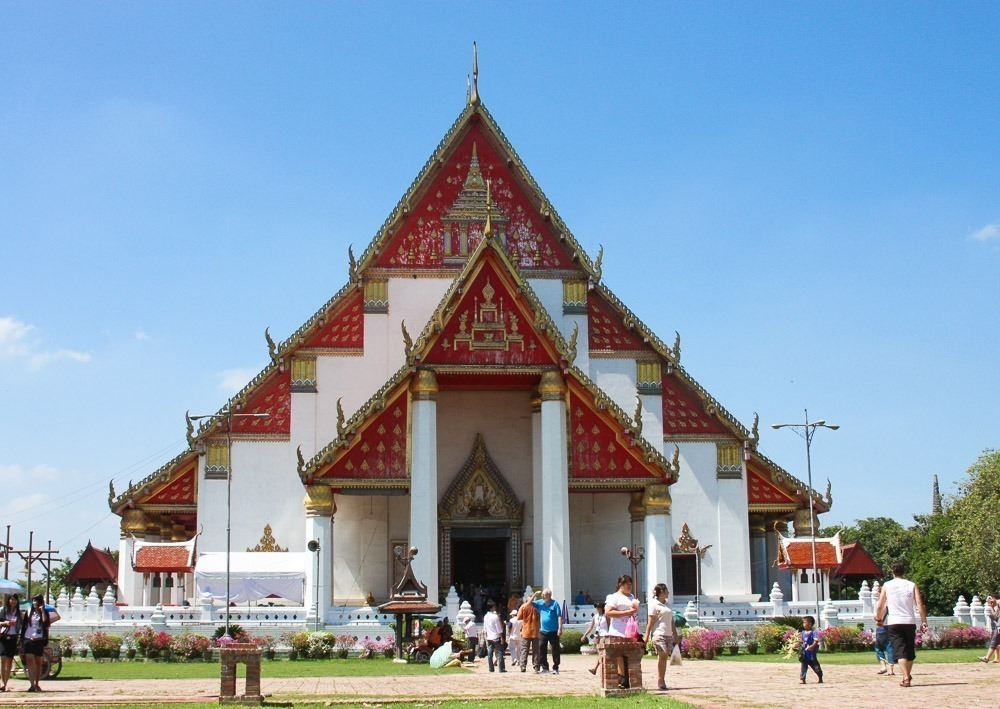 Templo Wihan Phra Mongkhon Bophit com fachada branca e telhado vermelho ornamentado.