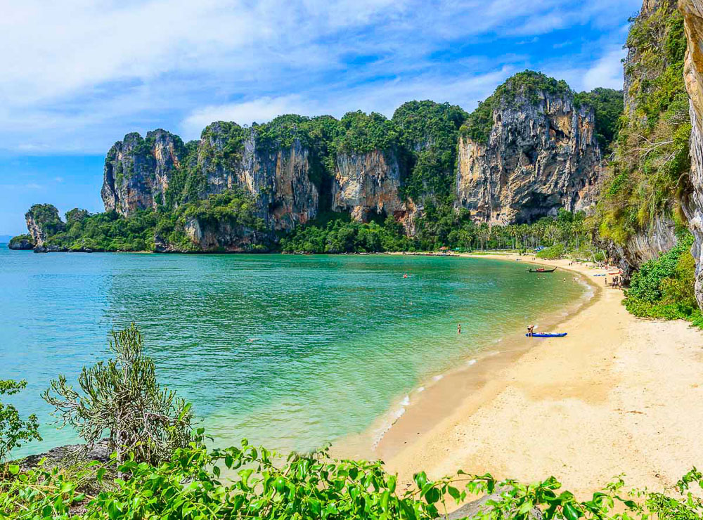 Vista panorâmica da praia de Tonsai com falésias ao fundo, areia dourada e mar azul esverdeado em Krabi.