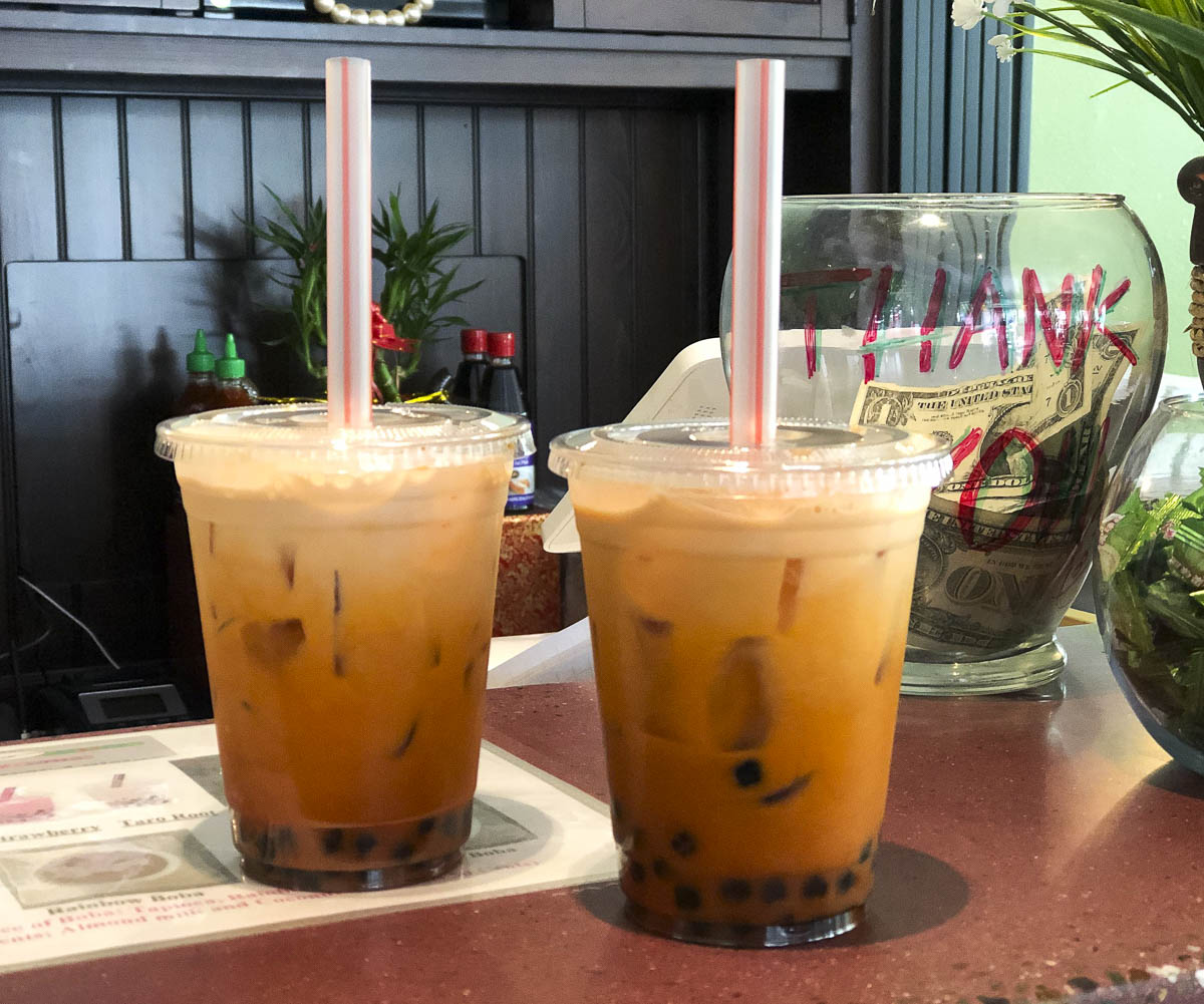Dois copos de chá tailandês com leite e bolinhas de tapioca.