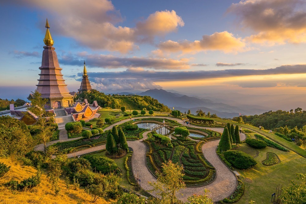 Doi Inthanon com as estupas gêmeas e jardins floridos emoldurados pelo pôr do sol nas montanhas.