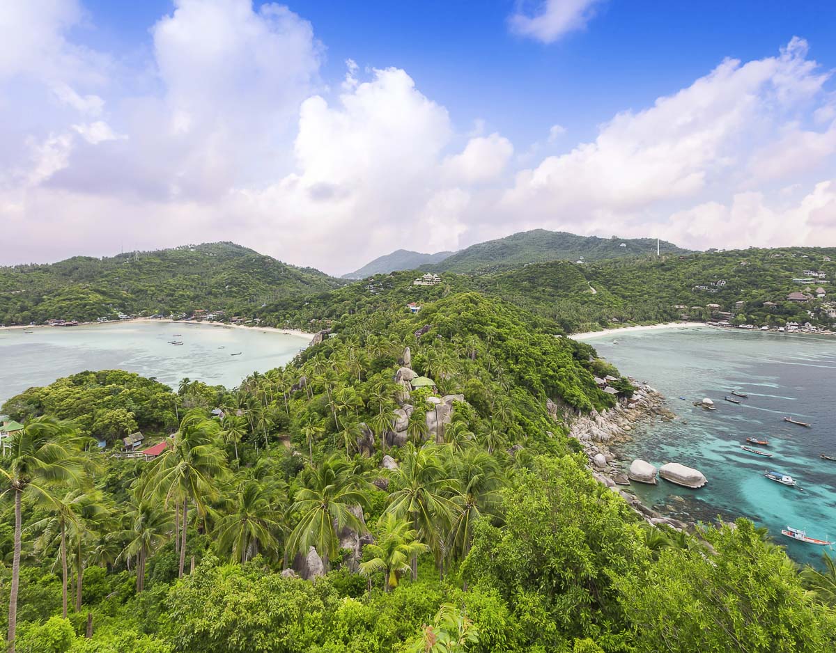 Mirante de Koh Tao com vista para duas praias separadas por faixa de vegetação e rochas.