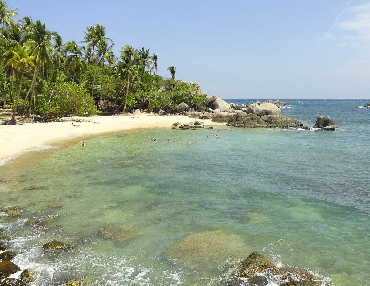 Praia deserta com mar verde e pedras grandes em Koh Tao.