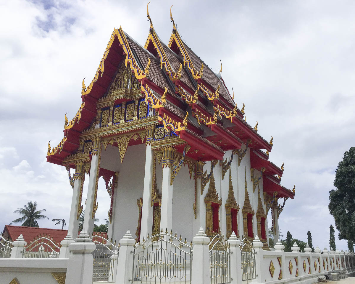 Templo budista tailandês com telhado vermelho e detalhes dourados em Koh Tao.